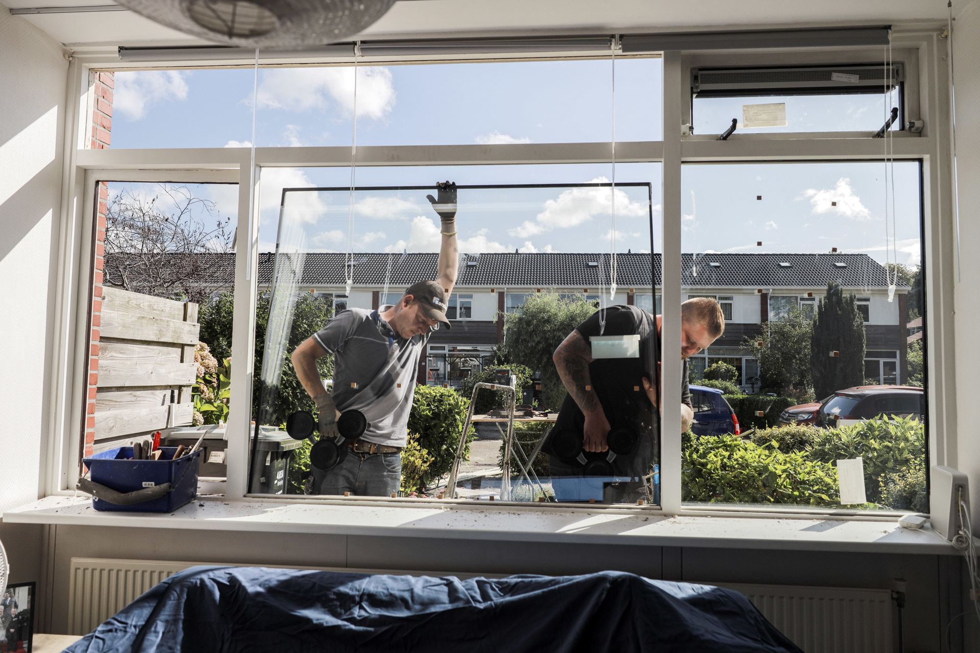 2 werklieden plaatsen dubbel glas in een huis